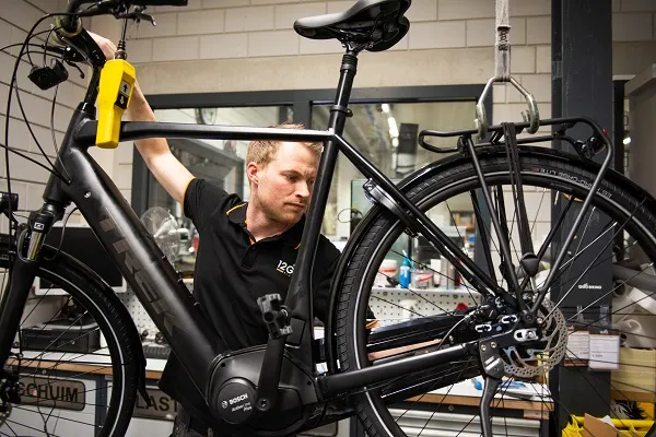 Monteur van 12GO Biking bouwt een fiets op